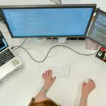 person using macbook pro on white table
